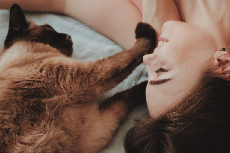 Woman Cuddling with Sweet Siamese Cat